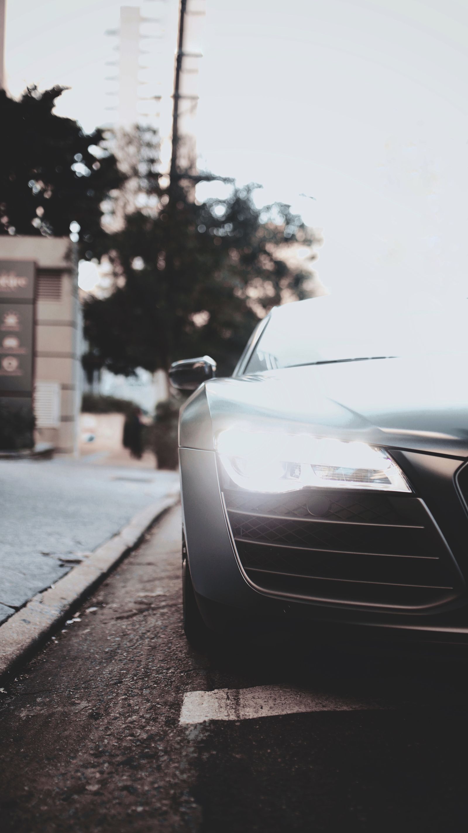 Car with headlights on the road at dusk