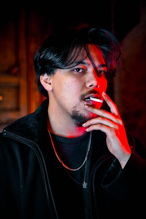 Free Intense portrait of a man with cigarette under dramatic red lighting indoors. Stock Photo