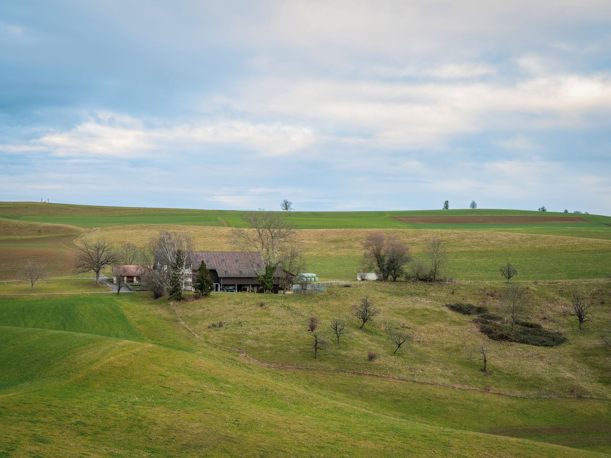 Rural Landscape with Farmhouse and Rolling Hills · Free Stock Photo