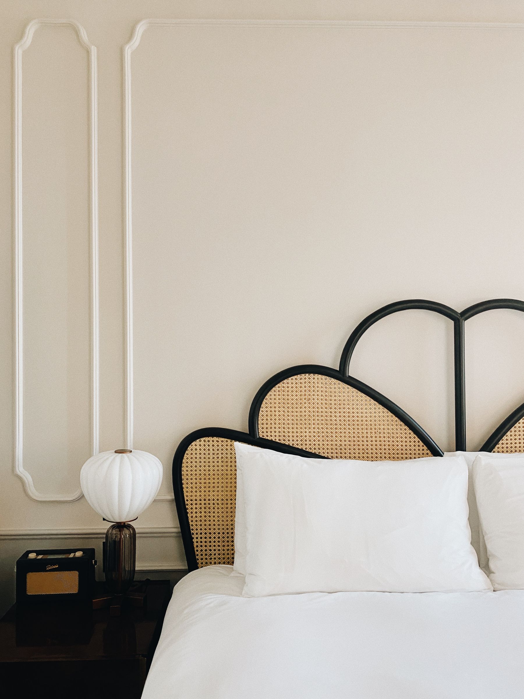Restrained Art Deco boutique-hotel bedroom with period wall moulding