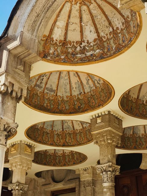 A detailed view of an ornate ceiling and stone columns in historic architecture.