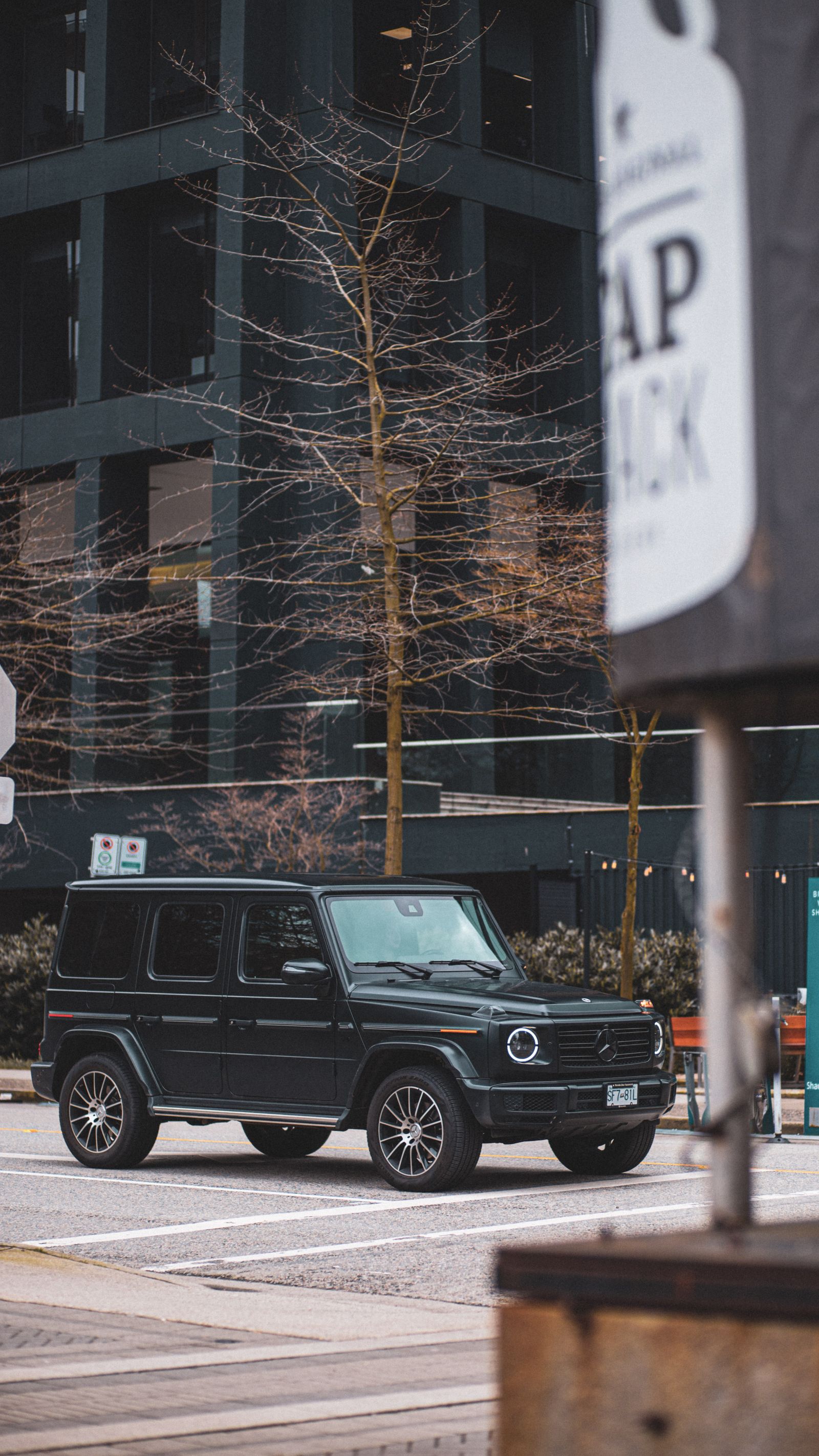 Professional chauffeur beside black SUV