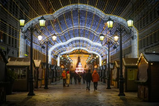 Christmas lights illuminate a festive street market in Saint Petersburg, capturing winter's charm.