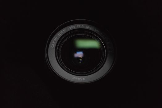 Detailed close-up shot of a DSLR camera lens against a dark background.
