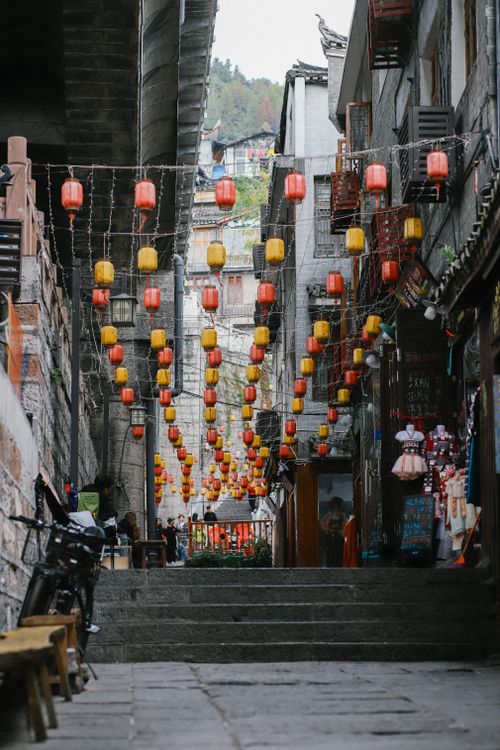 Free Colorful lanterns hanging over a narrow alley in an oriental city, creating a vibrant and traditional atmosphere. Stock Photo