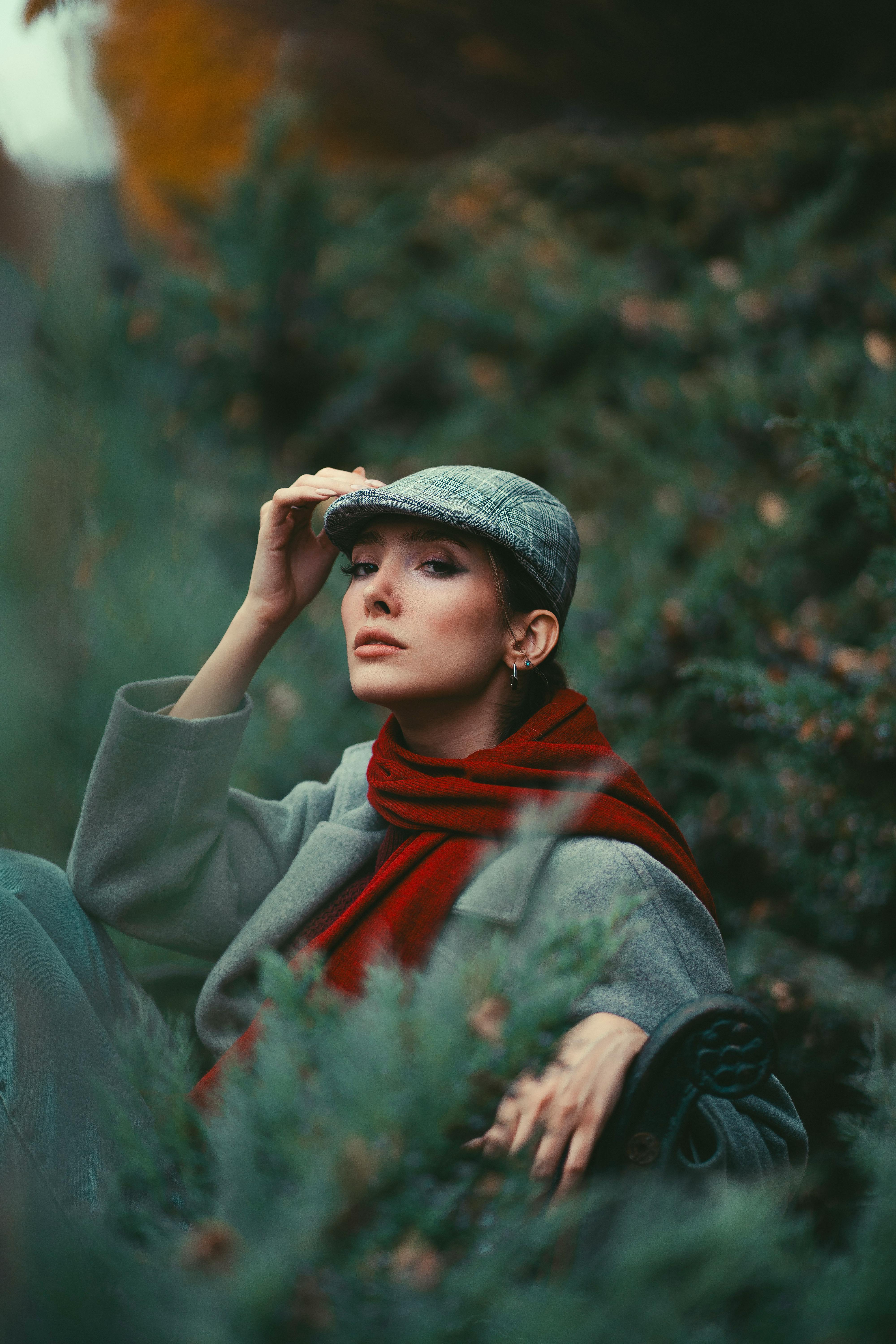 Elegant woman in outdoor setting with stylish attire, showcasing warm fall fashion.
