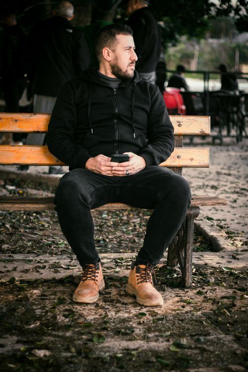 Free A man in casual attire sits on a park bench in Collo, Algeria, during the day. Stock Photo