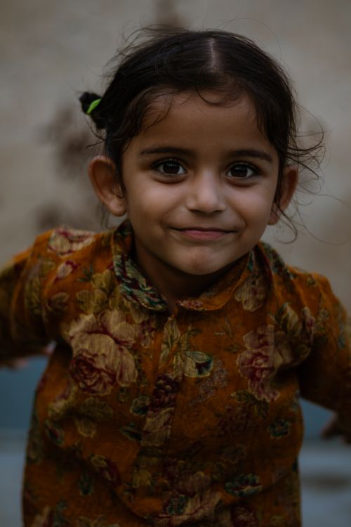 Free Charming portrait of a joyful child in floral traditional clothing, capturing innocence and happiness. Stock Photo
