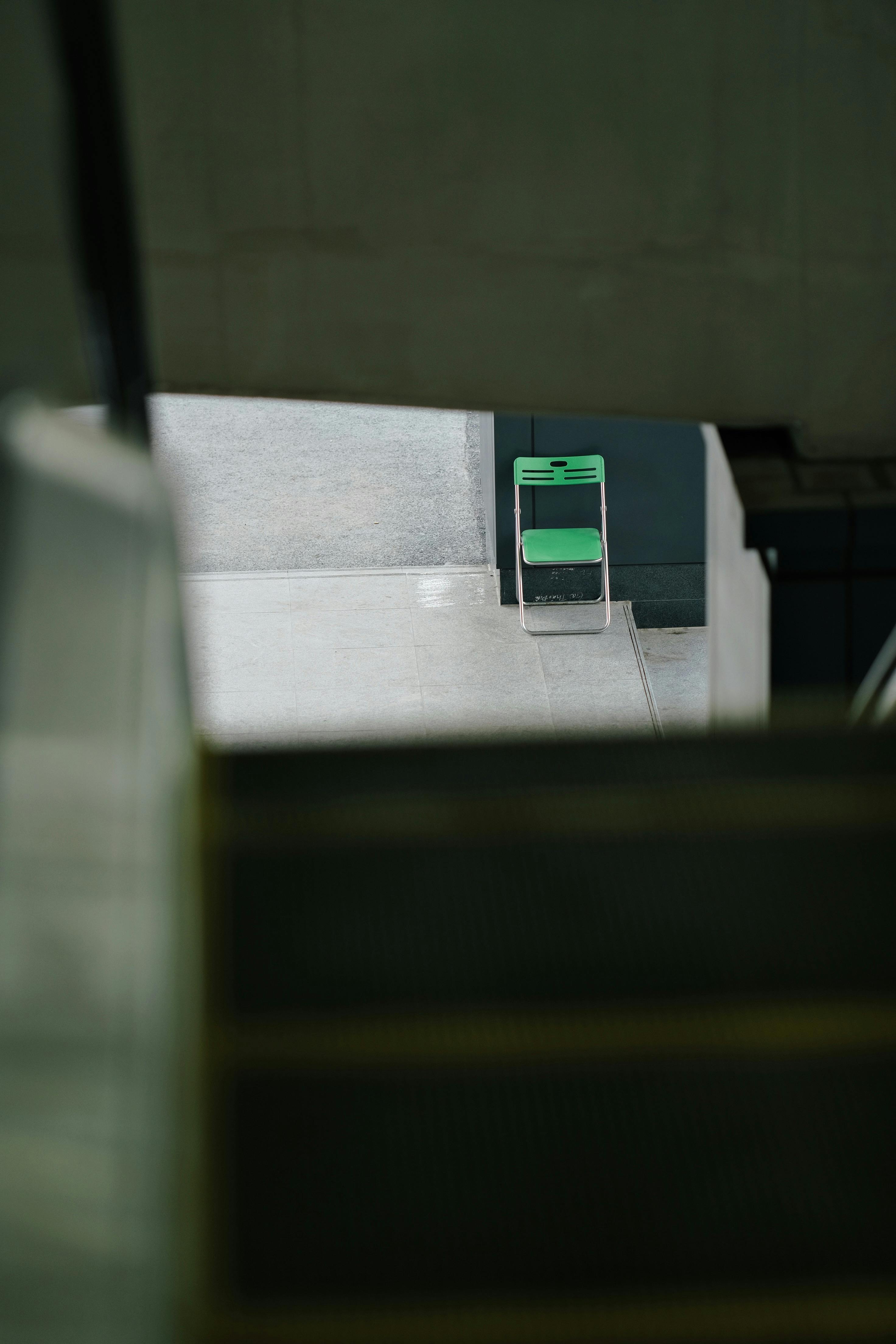 Gratuit Un scaun verde solitar într-un spațiu interior modern, beton, văzut de la distanță Fotografie de stoc