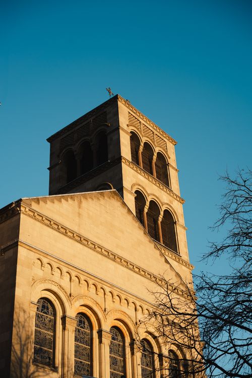 Free Dramatic view of a medieval church's ornate tower at sunset with clear blue sky. Stock Photo