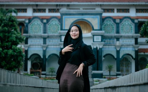 Free Confident woman in traditional attire posing against intricate Islamic architecture. Stock Photo