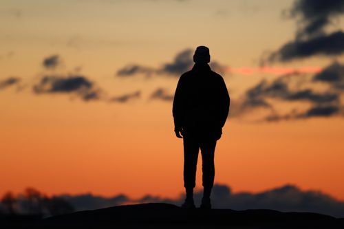 Free Silhouette of a person standing against a vibrant sunrise sky in Stamford, Connecticut. Stock Photo