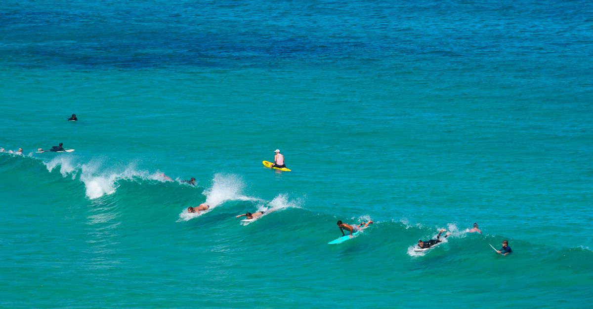Beach Wave Riding Rafts Surfers Riding Waves at Scenic Beachfront · Free Stock Photo