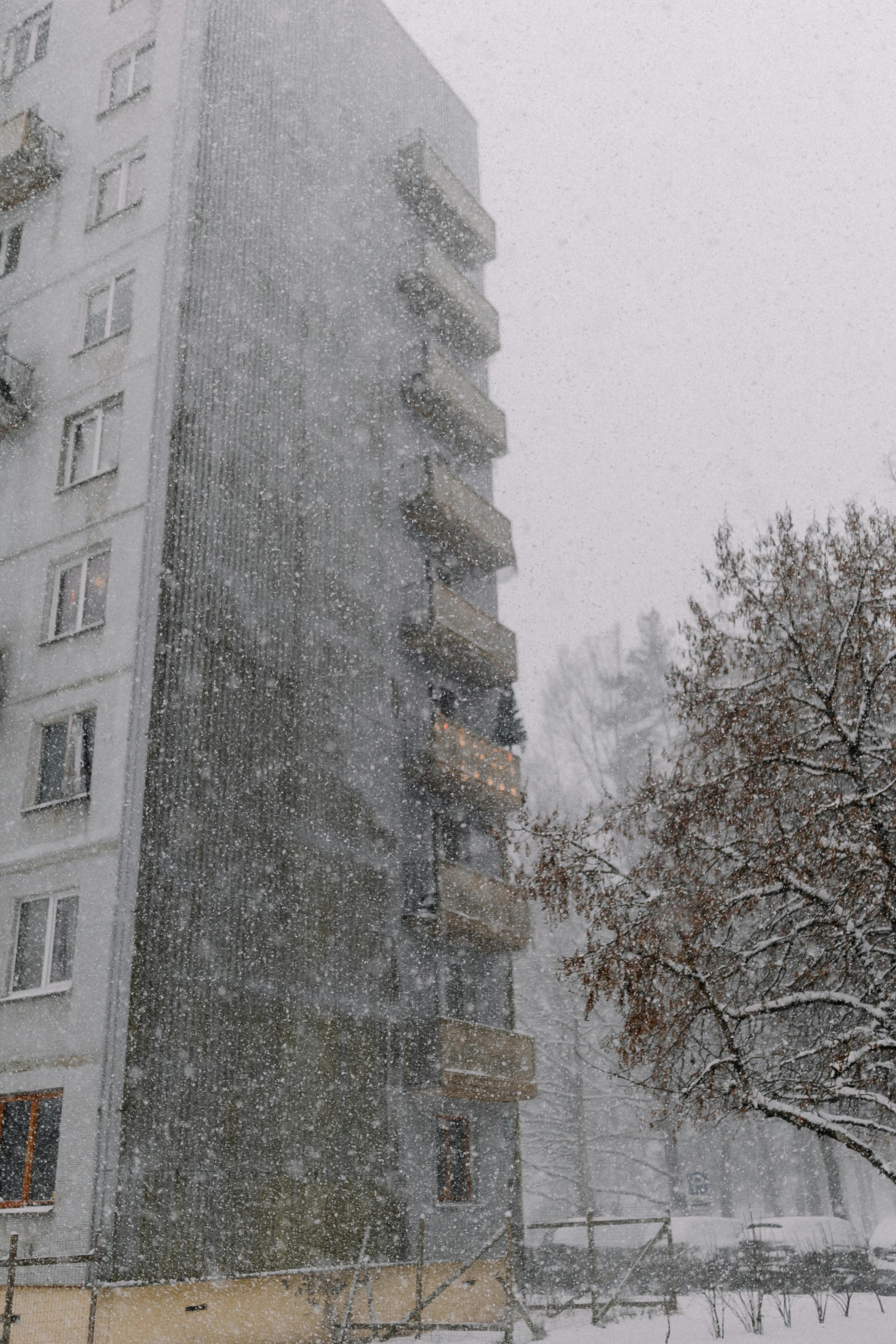 Snow-covered apartment building during winter blizzard, creating a serene urban scene.