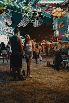 年轻人在夏季狂欢节上，伴着五彩缤纷的灯光和游乐设施，度过了一个热闹的夜晚