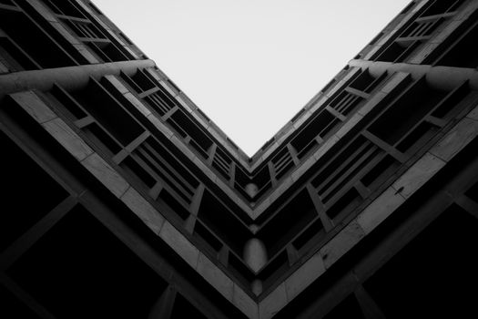 Striking black and white photograph of a modern building's geometric architecture with a dramatic perspective.