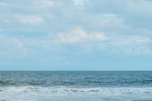 Tranquil ocean scene with gentle waves and a clear blue sky, evoking a sense of peace.
