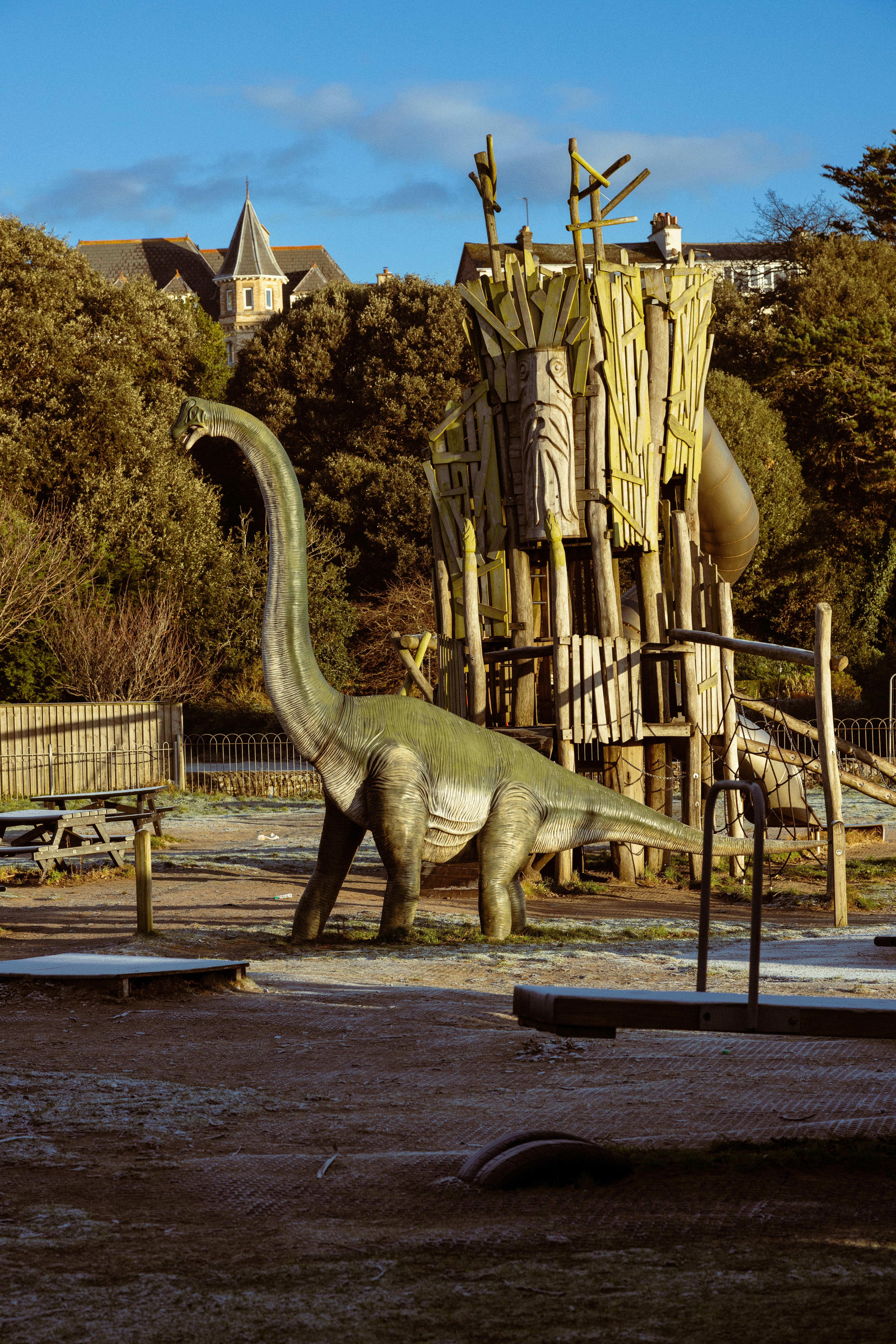 Ilmainen Leikkialue, jossa on dinosauruspatsas ja puurakenteita aurinkoisena päivänä Exmouthissa, Englannissa. Kuvapankkikuva