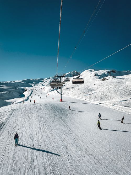 Free Scenic view of skiers enjoying a sunny day on Les Arcs slopes in France. Stock Photo
