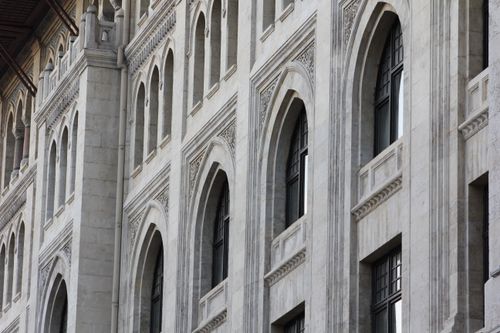 Free Close-up of a classic architectural facade featuring elegant arched windows and intricate stonework. Stock Photo