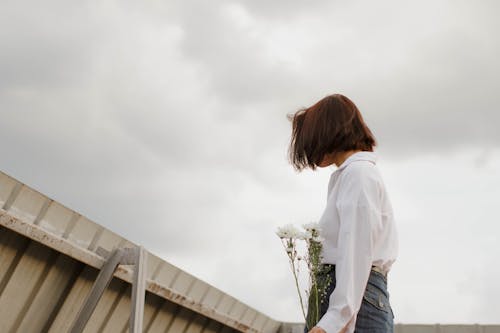 Woman Wearing White Shirt Holding Flowers