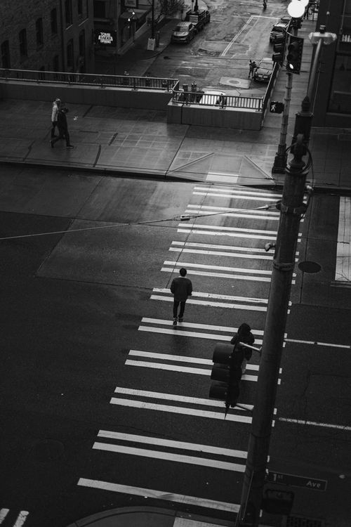 Free A moody black and white street view in Seattle with people crossing at night. Stock Photo