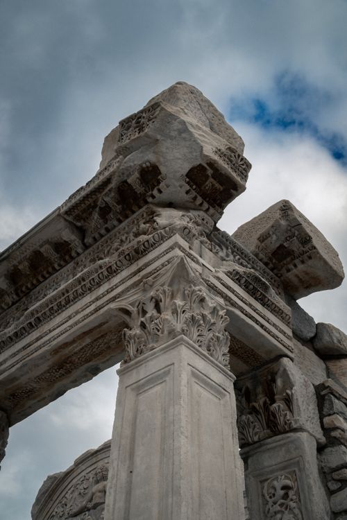 Free Close-up of ornate columns in Ephesus, Türkiye under dramatic clouds. Stock Photo