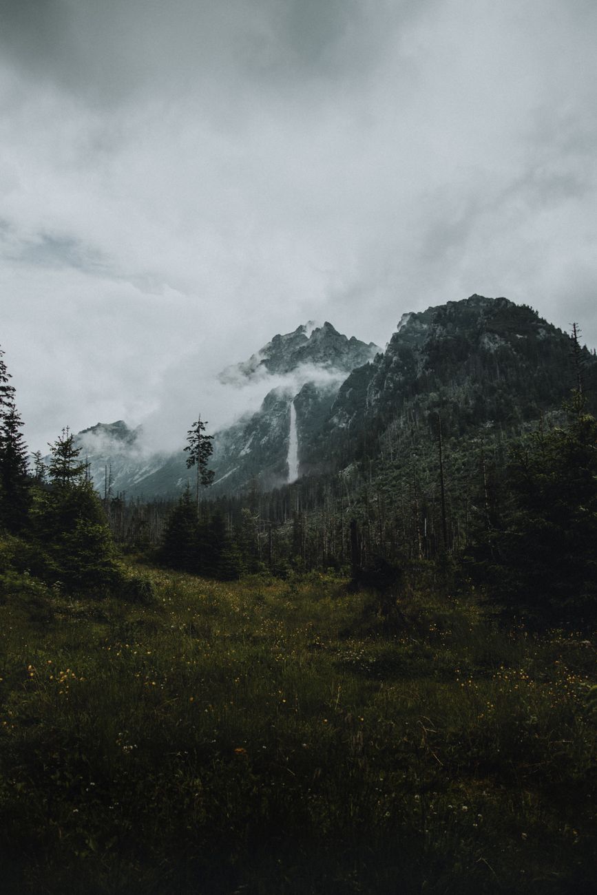 Dramatic mountain scenery with mist and waterfall in Vysoké Tatry, Slovakia.