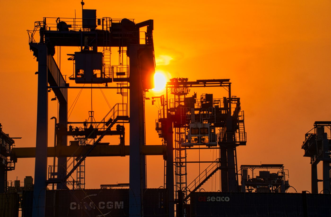 Industrial cranes silhouetted at sunset