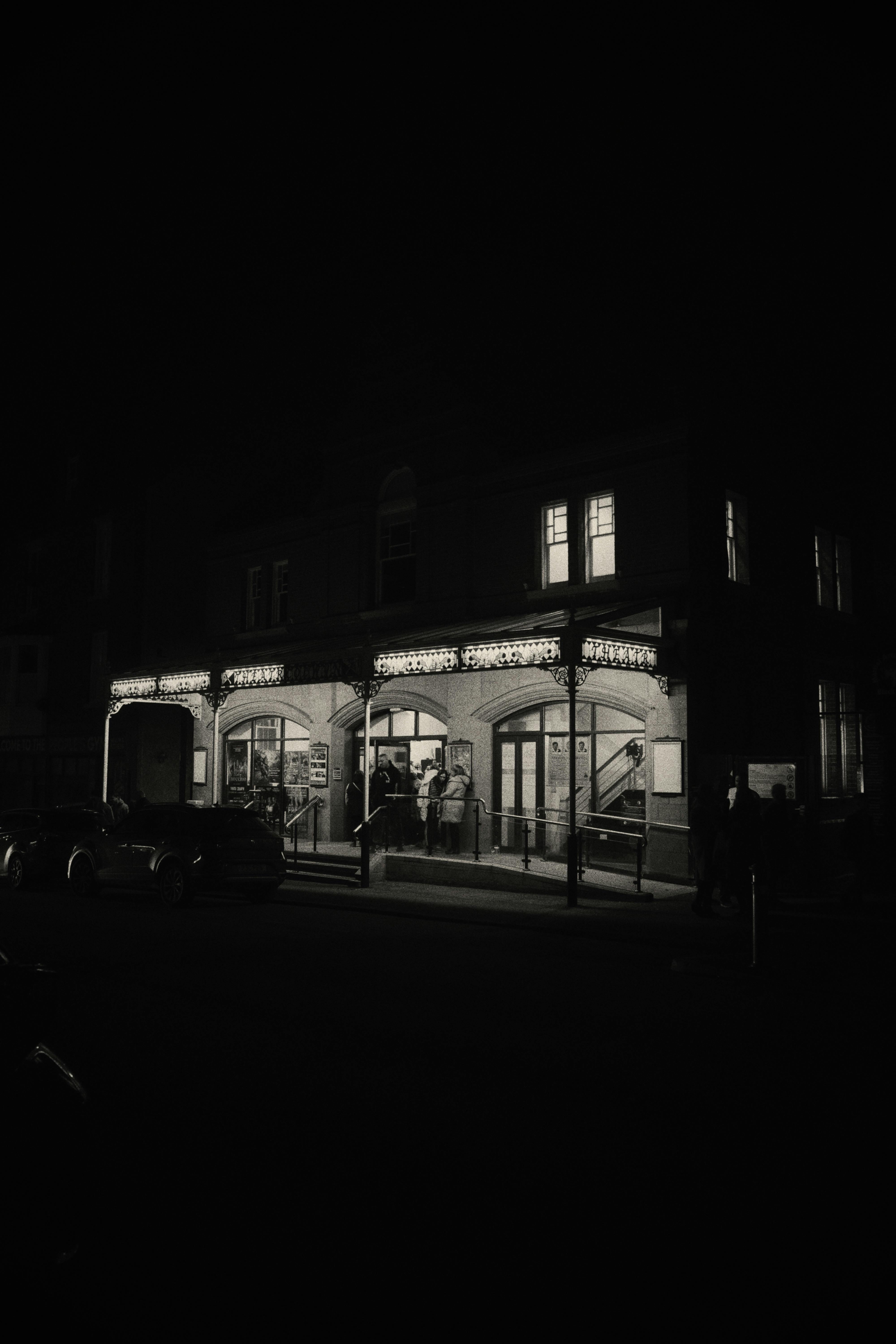 Free Elegant theater entrance glowing at night in a classic black and white capture. Stock Photo