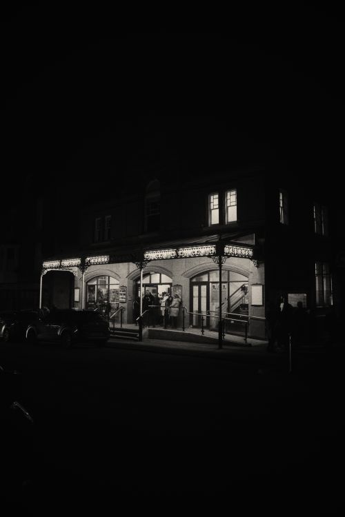 Free Elegant theater entrance glowing at night in a classic black and white capture. Stock Photo