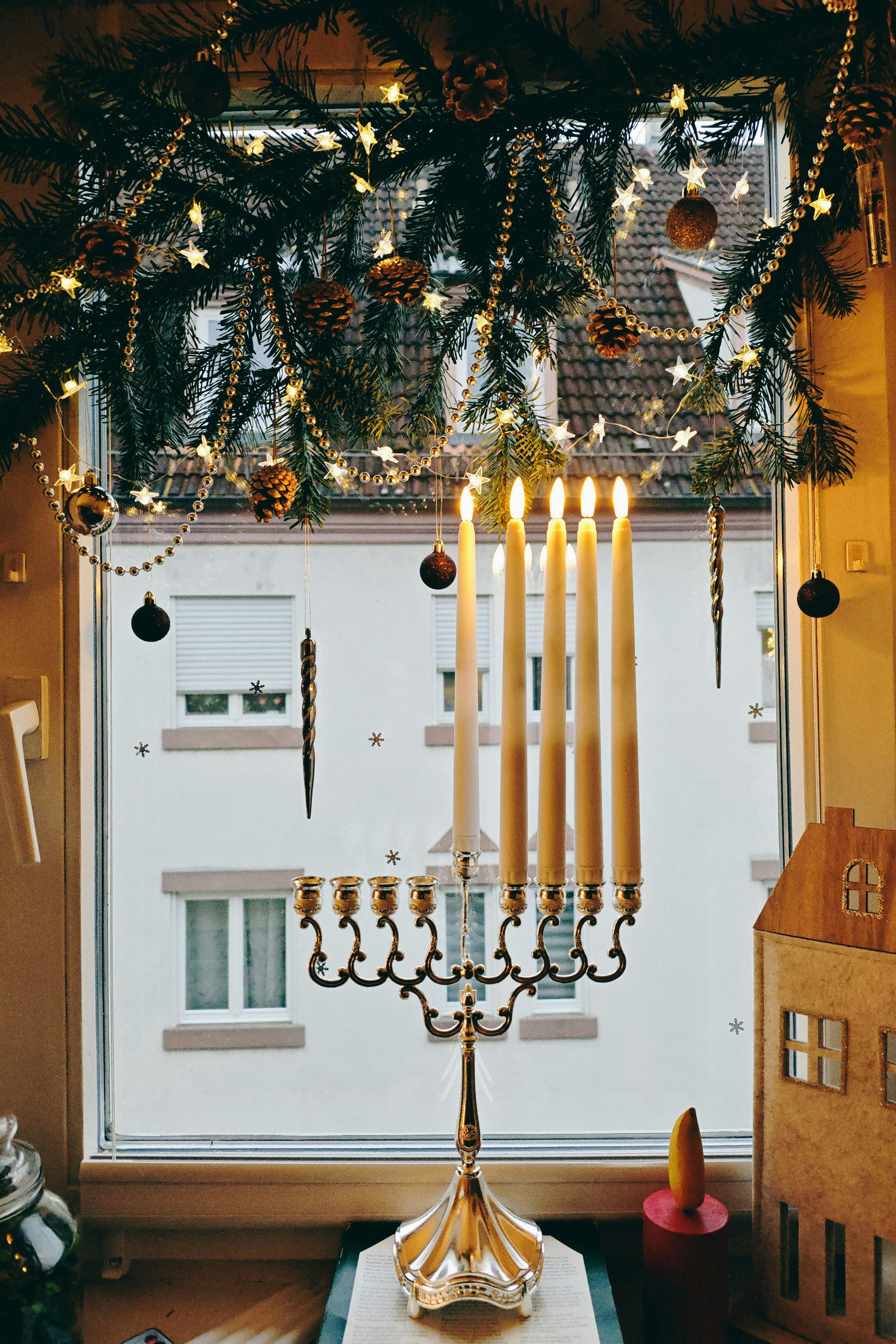 Cozy holiday window with a lit menorah and festive decorations.