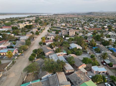 Aerial shot of a peaceful residential neighborhood with greenery in the afternoon light.