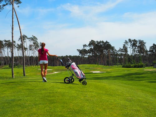 Free Back View of a Woman Walking at a Golf Course Stock Photo
