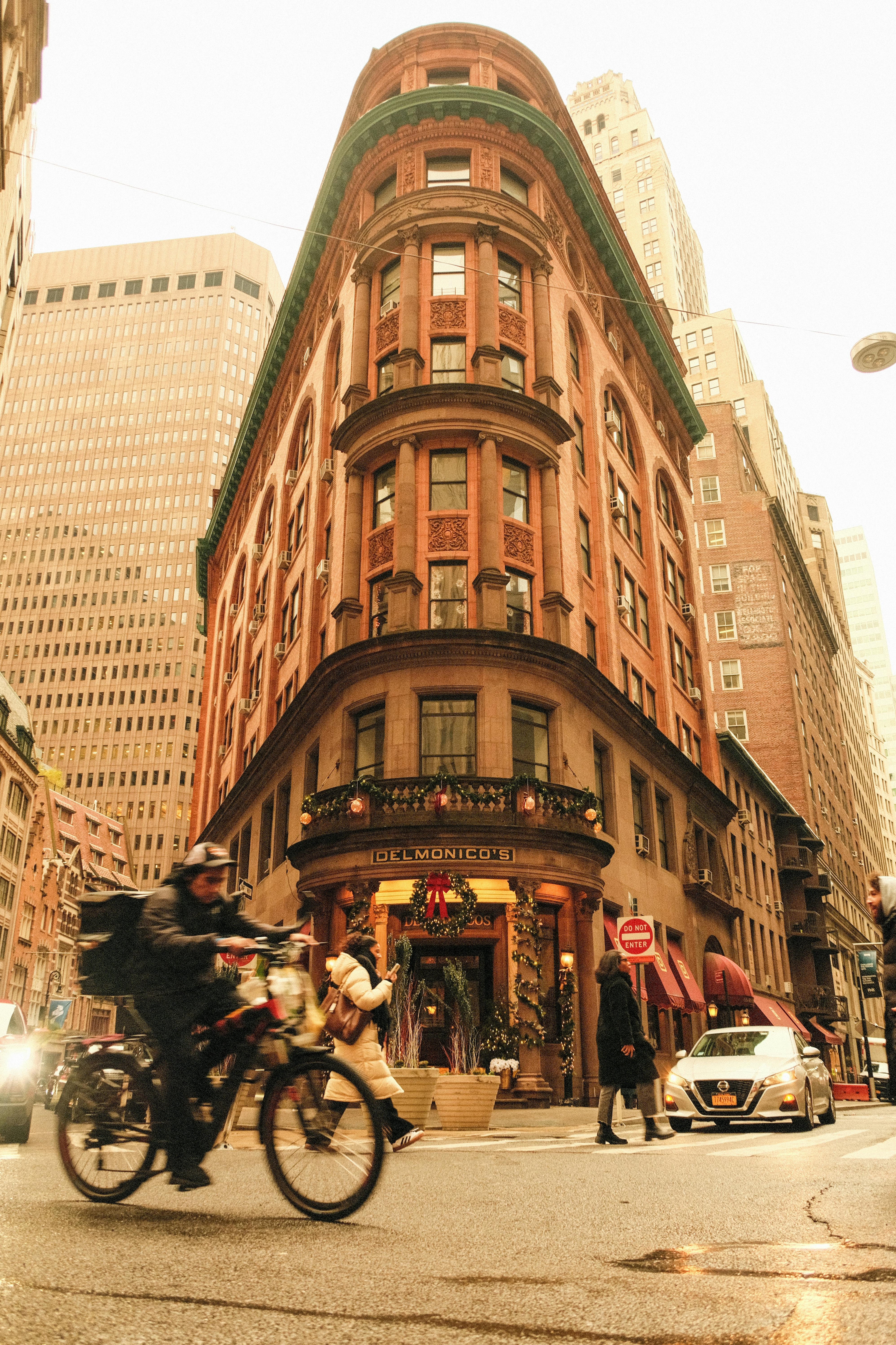 Urban scene with people and traffic by historic corner building.