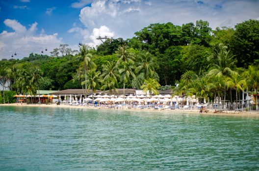 Scenic tropical beach resort with palm trees and azure water, ideal for a summer getaway.
