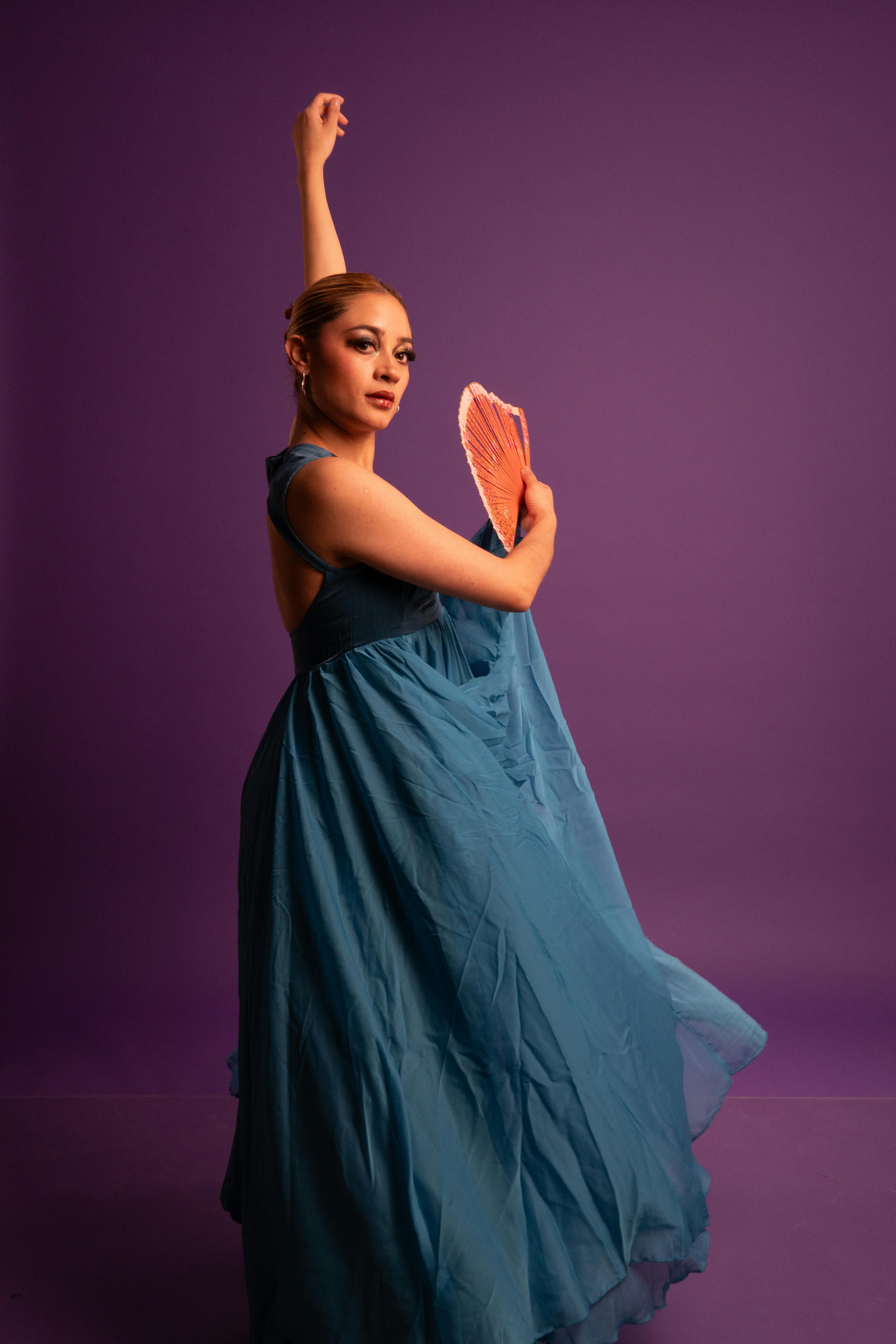 bezplatná Elegantní flamenková tanečnice pózující s ventilátorem v pulzujícím prostředí studia. Základová fotografie