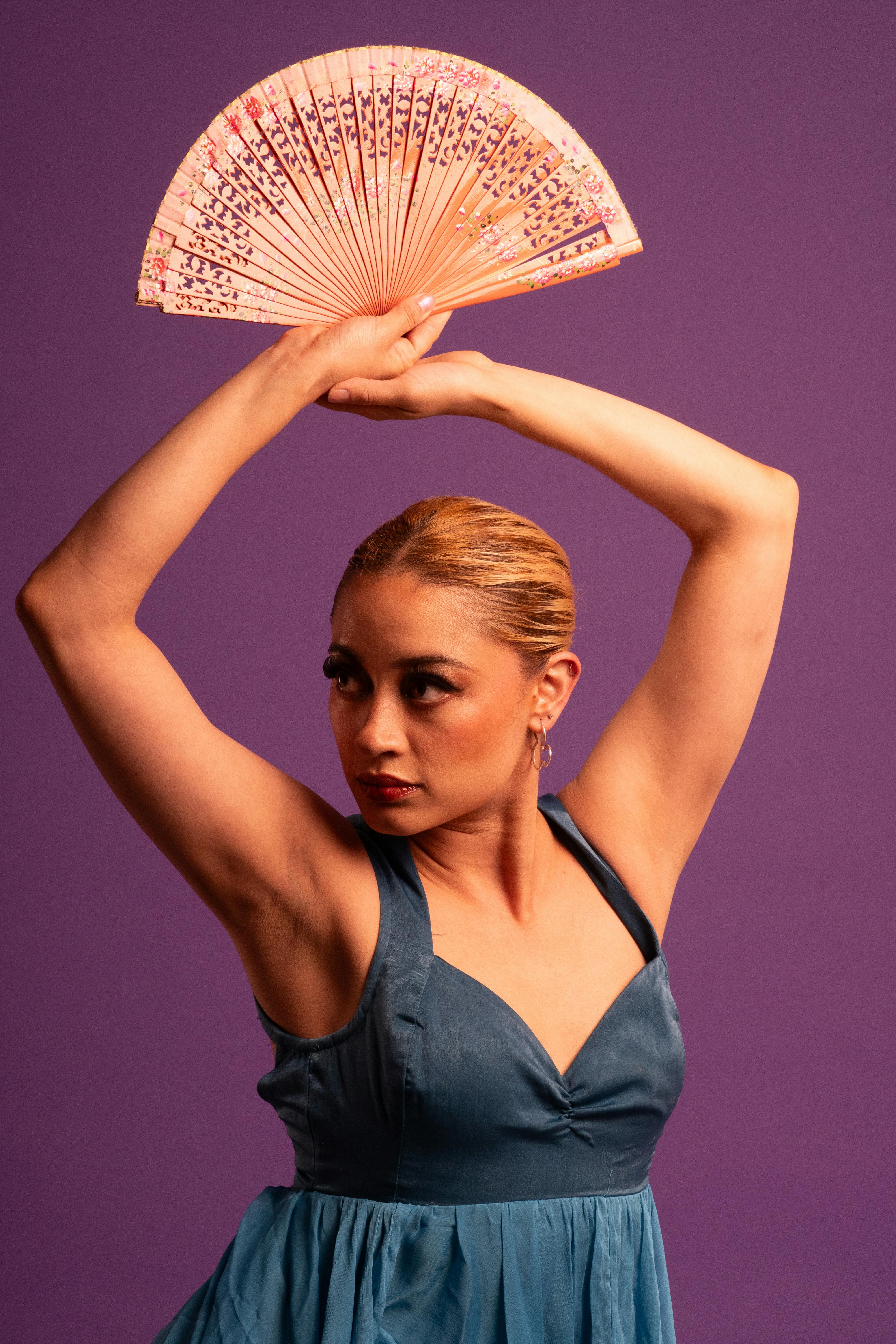 bezplatná Studio záběr tanečnice flamenca v modrých šatech s tradičním vějířem a fialovým pozadím. Základová fotografie