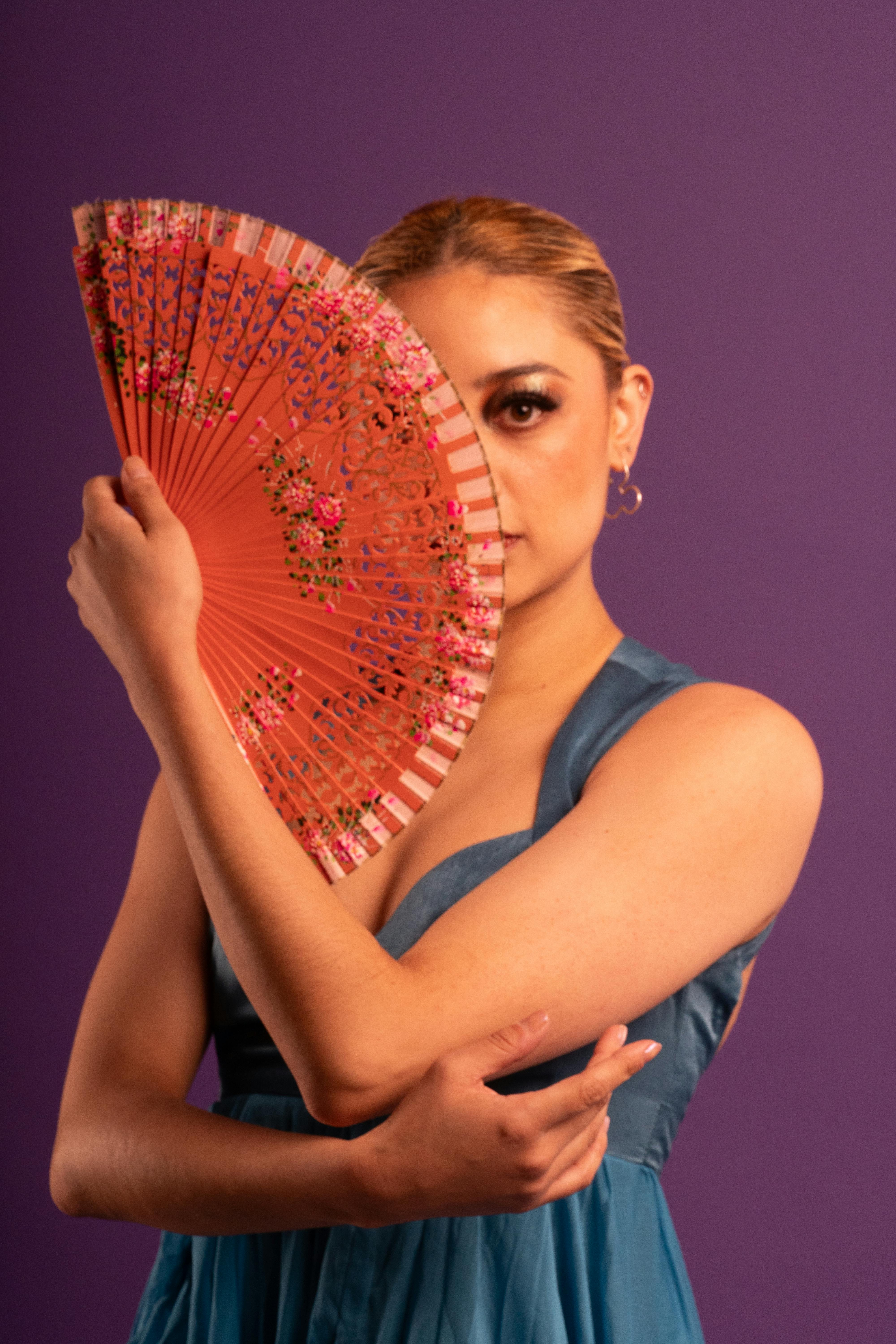 Gratuit Portrait d'une femme avec un éventail décoré, embrassant la culture et le style mexicain. Photos