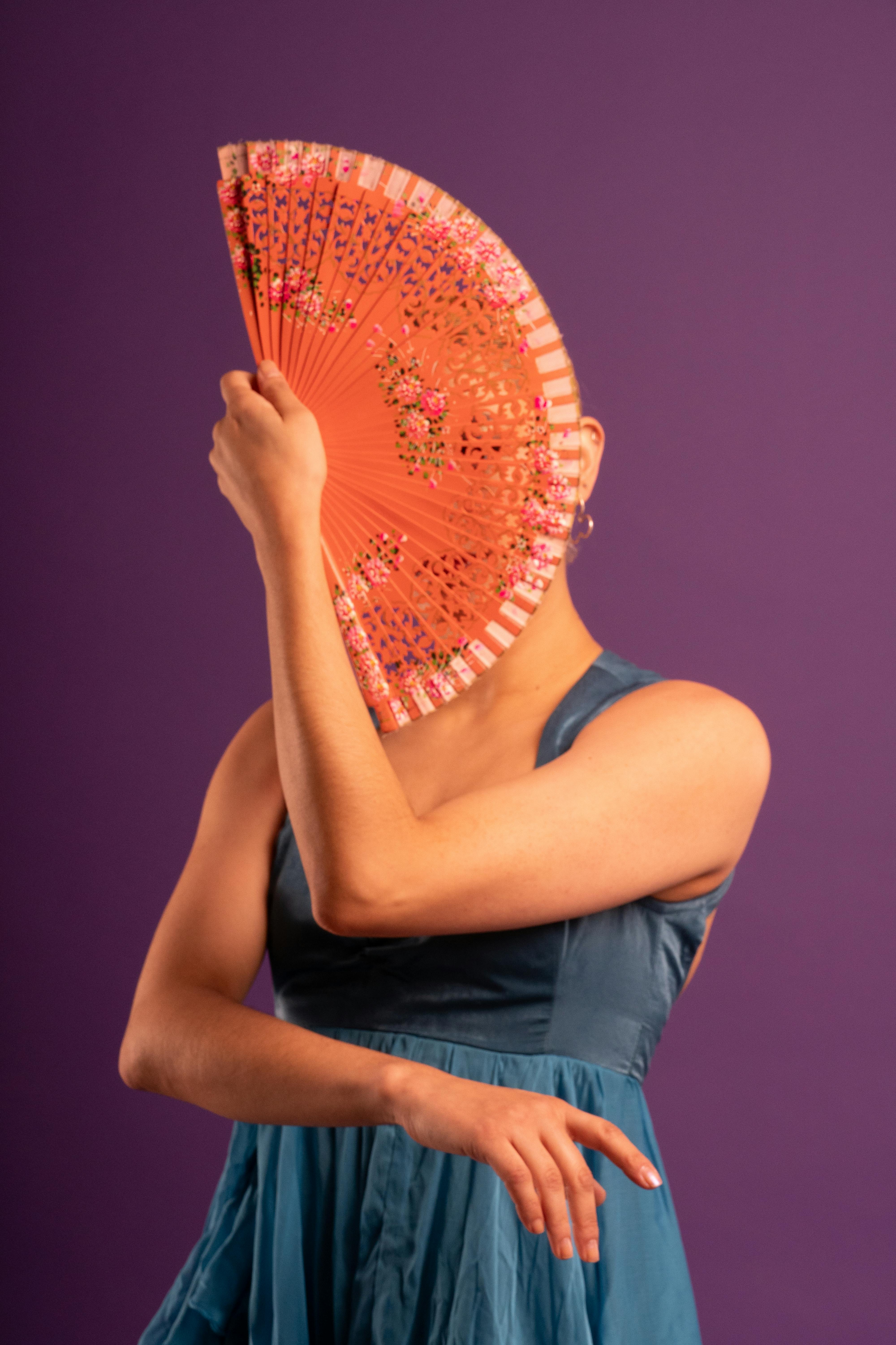 Gratis Model dengan kipas yang menutupi wajah, menonjolkan gaya Flamenco di studio. Foto Stok