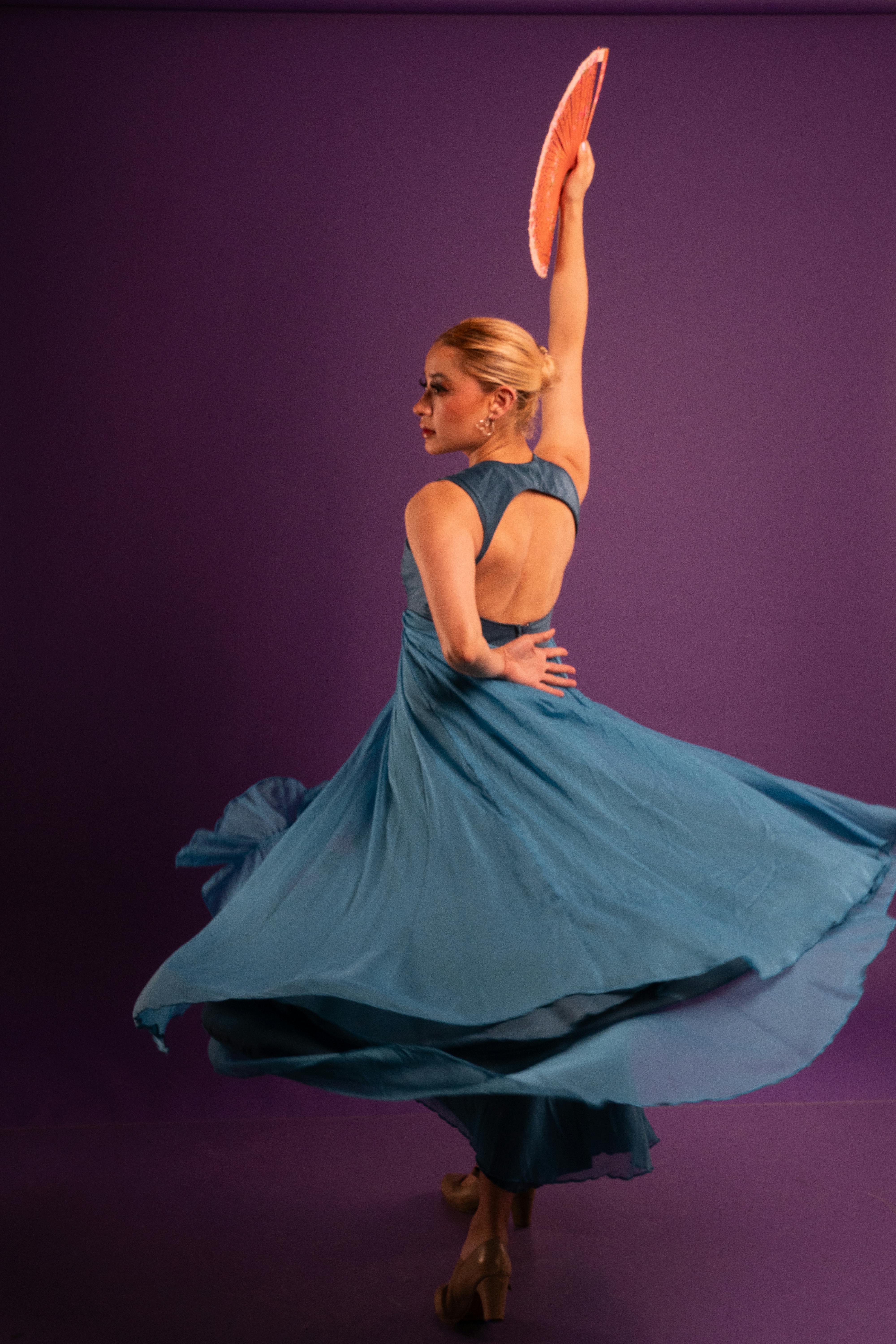 Gratuit Danseuse de flamenco gracieuse dans une robe bleue avec éventail sur fond de studio violet. Photos