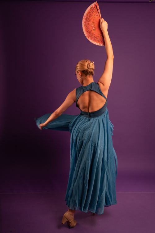 Free Professional model performing flamenco dance in a blue dress with fan indoors. Stock Photo