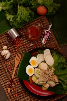 Top view of plate with delicious dish placed on cafe table near utensils and ingredients on summer day