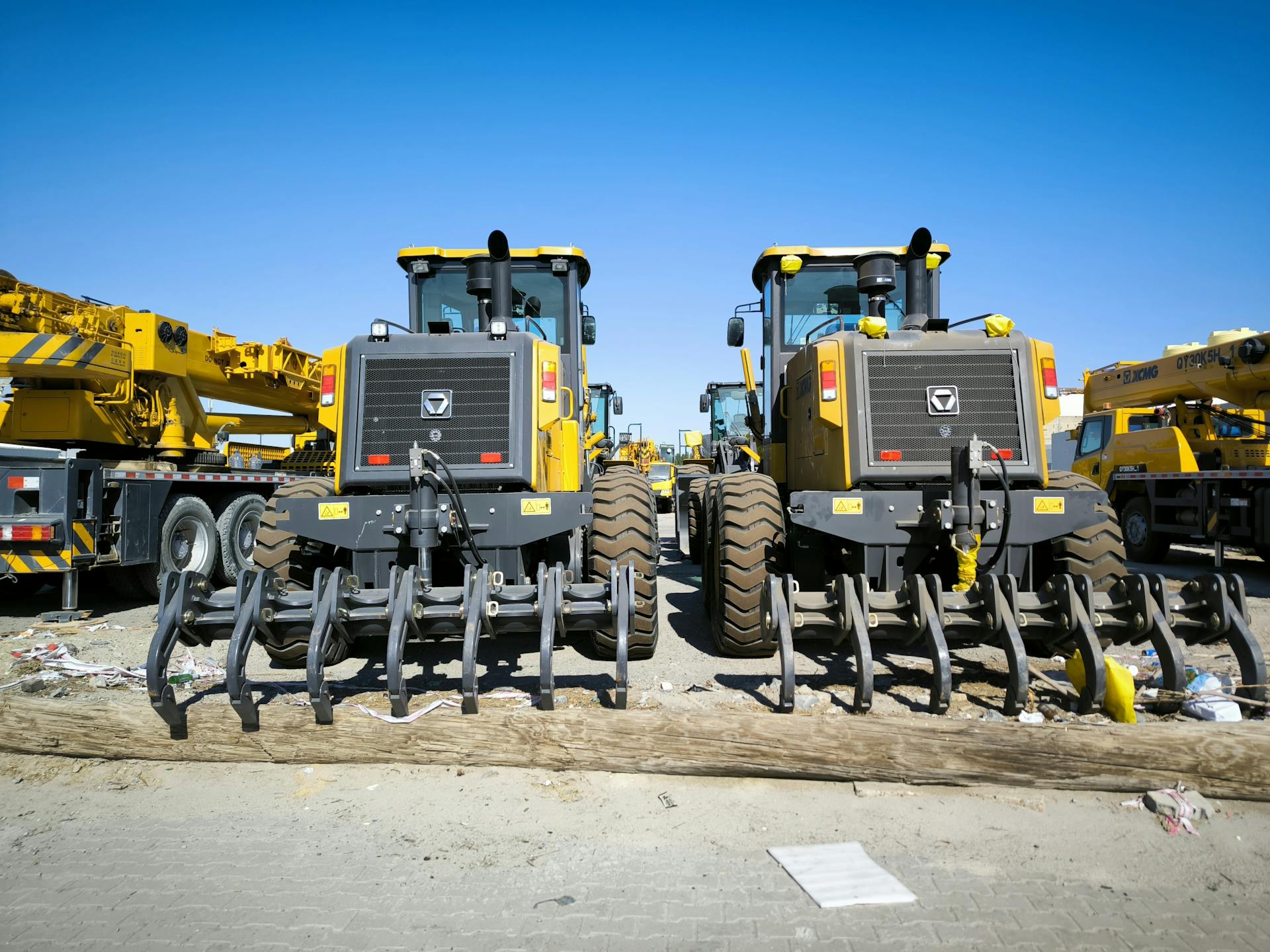 Close-up of heavy machinery at a construction site with clear blue skies.