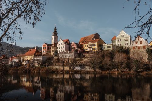 Free A picturesque view of Frohnleiten with colorful buildings reflected in a river. Stock Photo