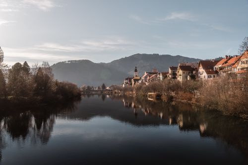 Free Tranquil morning view of Frohnleiten, Austria with reflections on the Mur River. Stock Photo