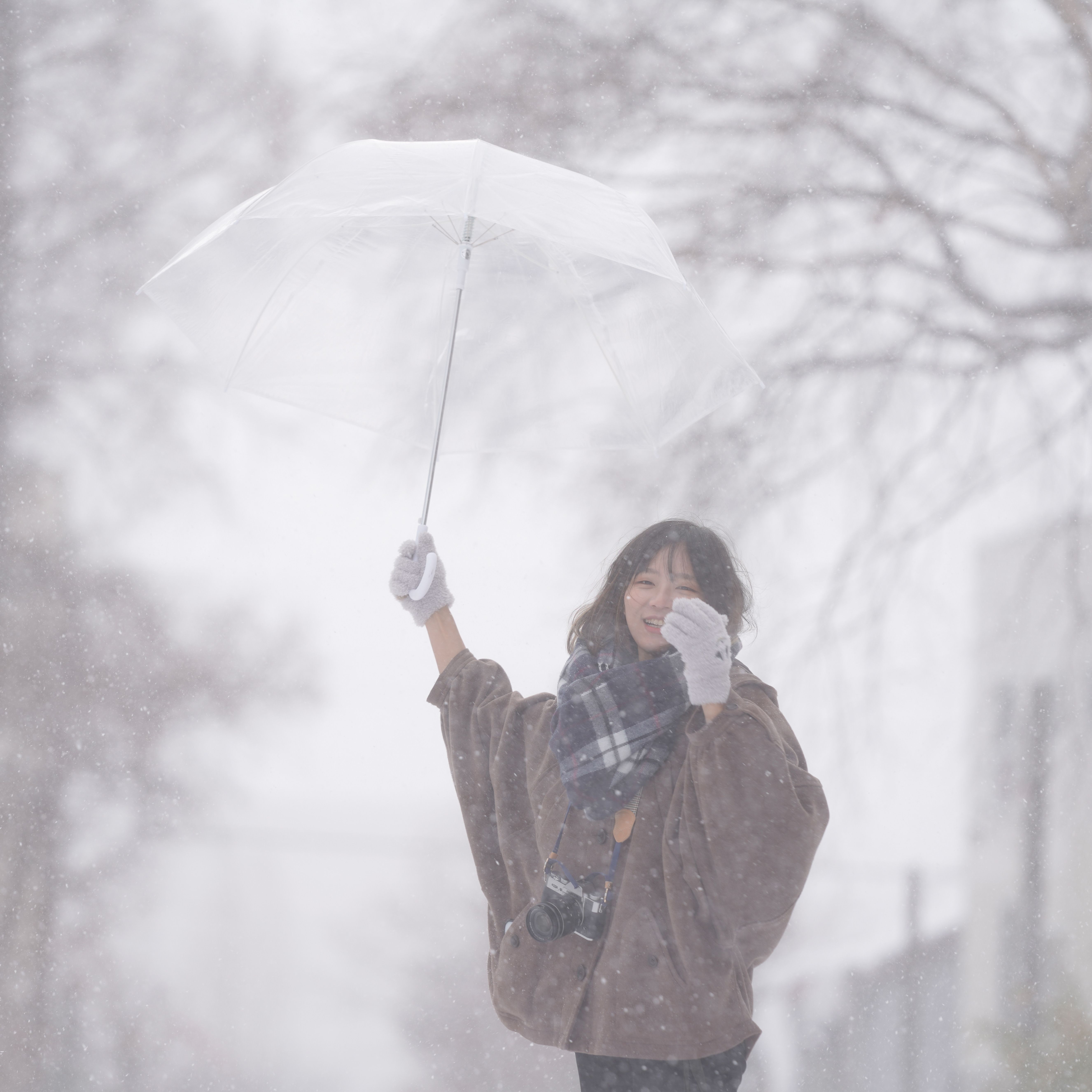 Woman with umbrella enjoying a snowy day outdoors, a perfect winter scene of joy and adventure.