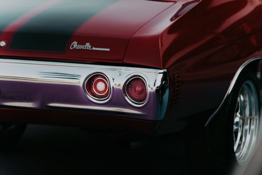 Detailed shot of a vintage red Chevrolet muscle car's rear with chrome detailing.