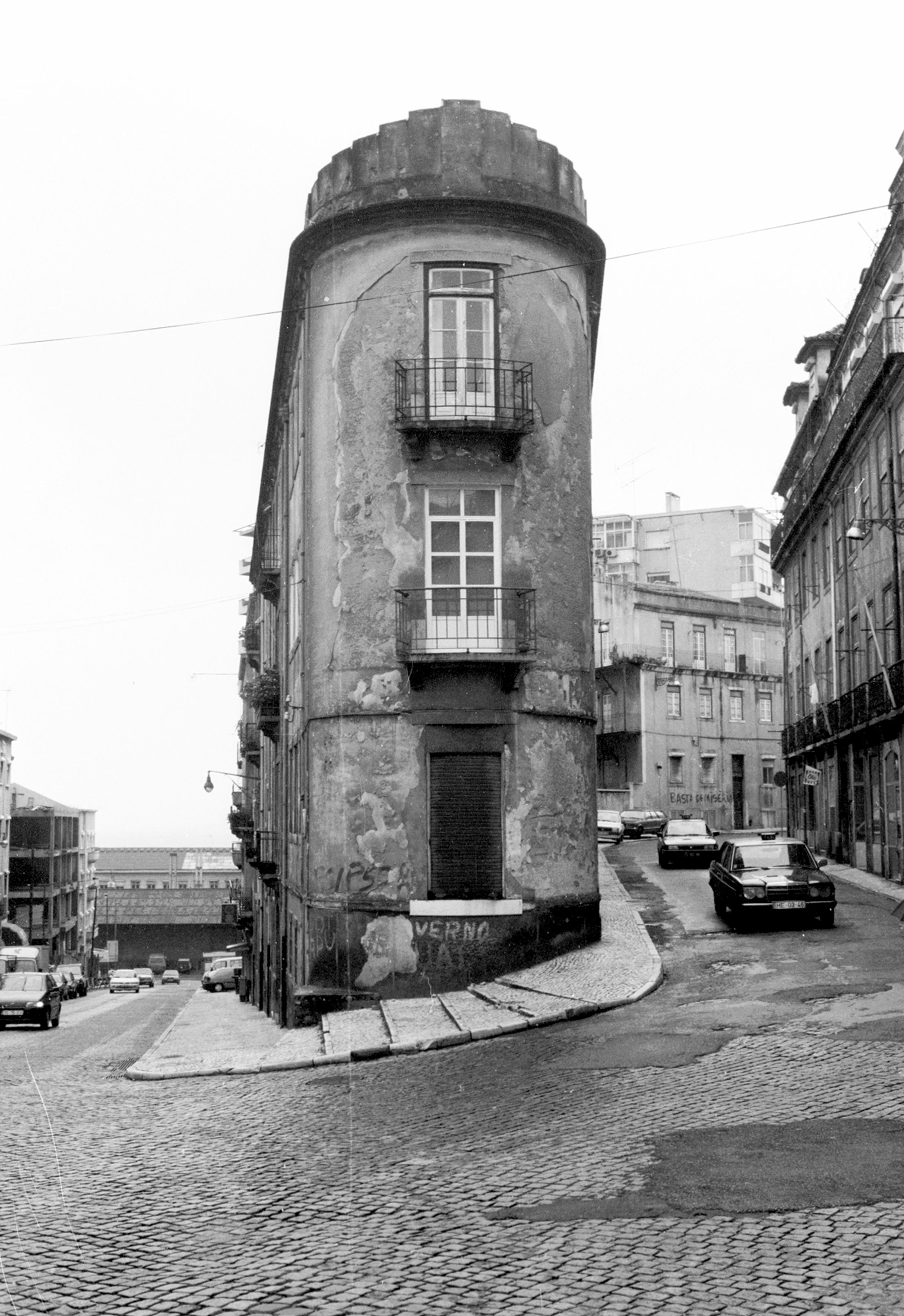 Vintage photo of unique narrow building on Lisbon street, showcasing classic architecture.