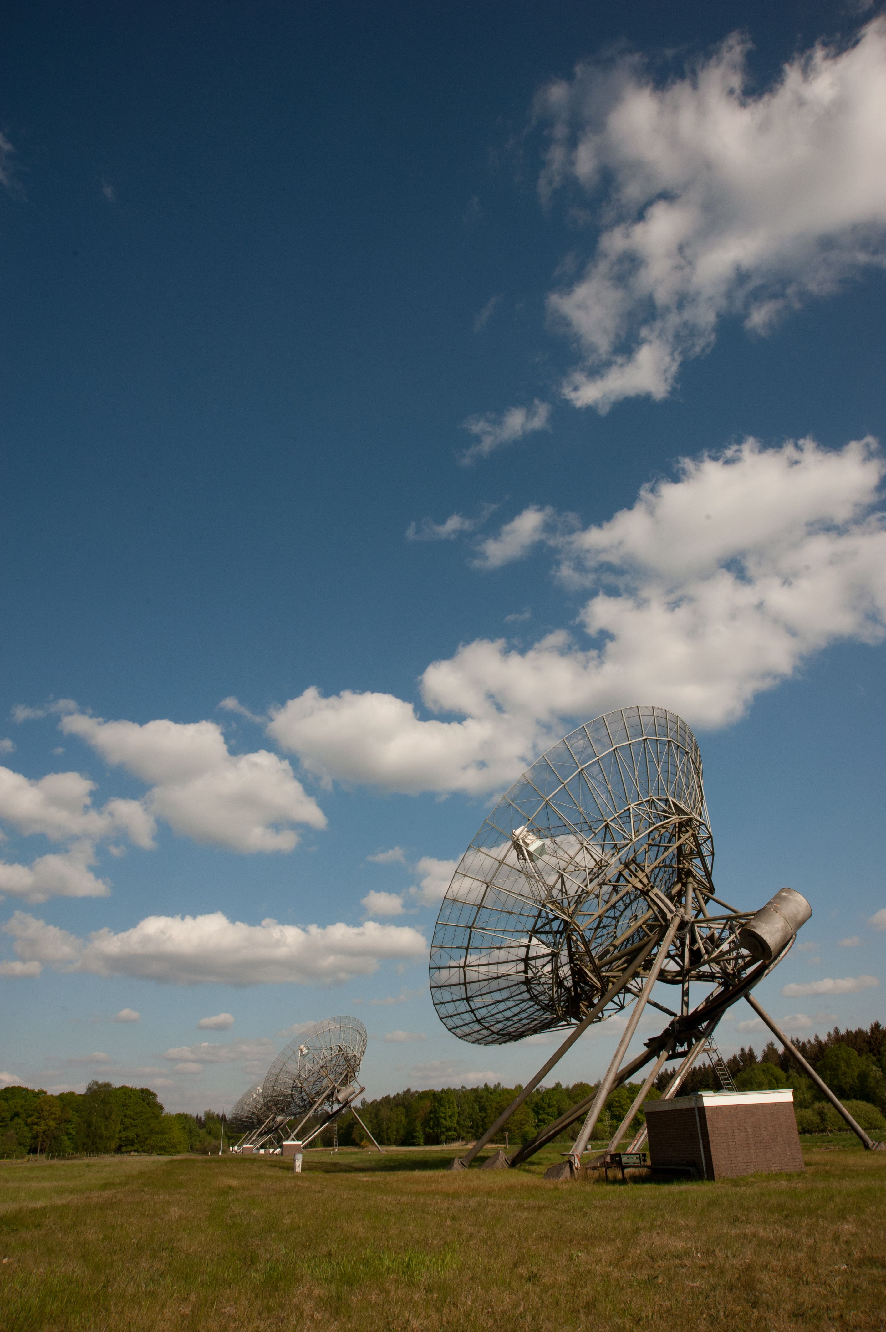 Radio telescopes in Dwingeloo, Drenthe, Netherlands against a clear blue sky.
